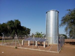 Equipements d’adduction d’eau potable par énergie solaire (panneaux solaires et réservoir), au Mozambique. Equipement of solar-powered water supply networks (solar panels and tank), in Mozambique.