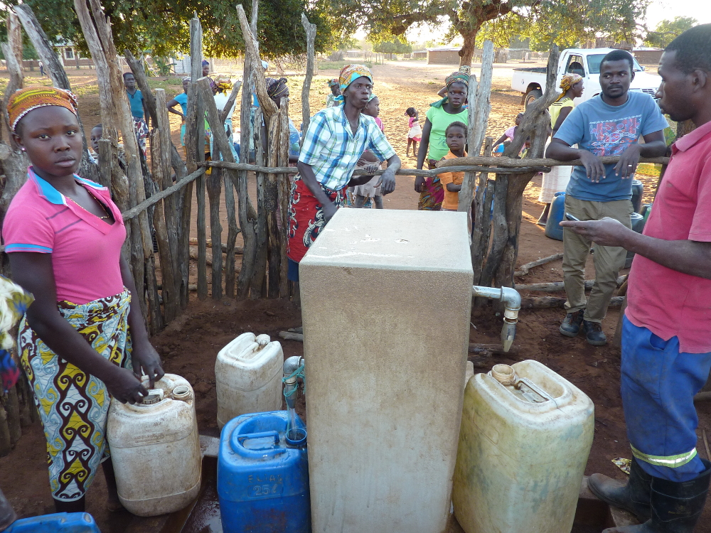 Villageois tirant de l'eau à une fontaine, au Mozambique. Rural people getting water out of a fountain, in Mozambique.