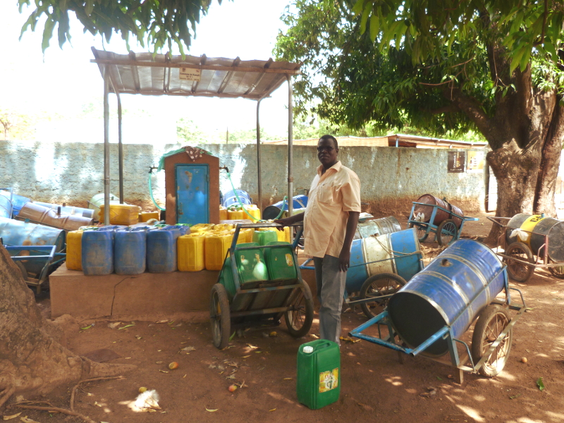 Jean-Christophe KI, Directeur Général de VERGNET BURKINA, auprès d'une borne fontaine prise en gestion sur la commune rurale de Kampti (Région Sud-Ouest).