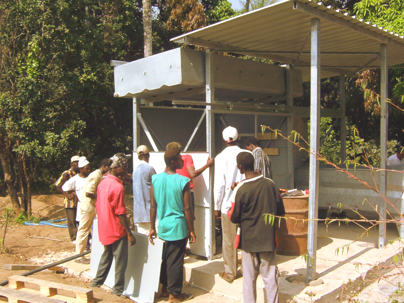 Artisans guinéens installant une unité HYDROPUR. Guinean workers installing a HYDROPUR unit.